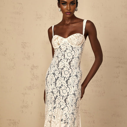 Woman wearing long white lace dress with floral pattern and bustier top