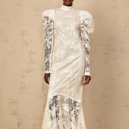 Woman wearing long white lace mermaid style dress with floral pattern and fitted silhouette