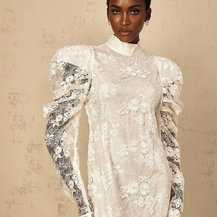 Woman wearing long white lace mermaid style dress with floral pattern and fitted silhouette