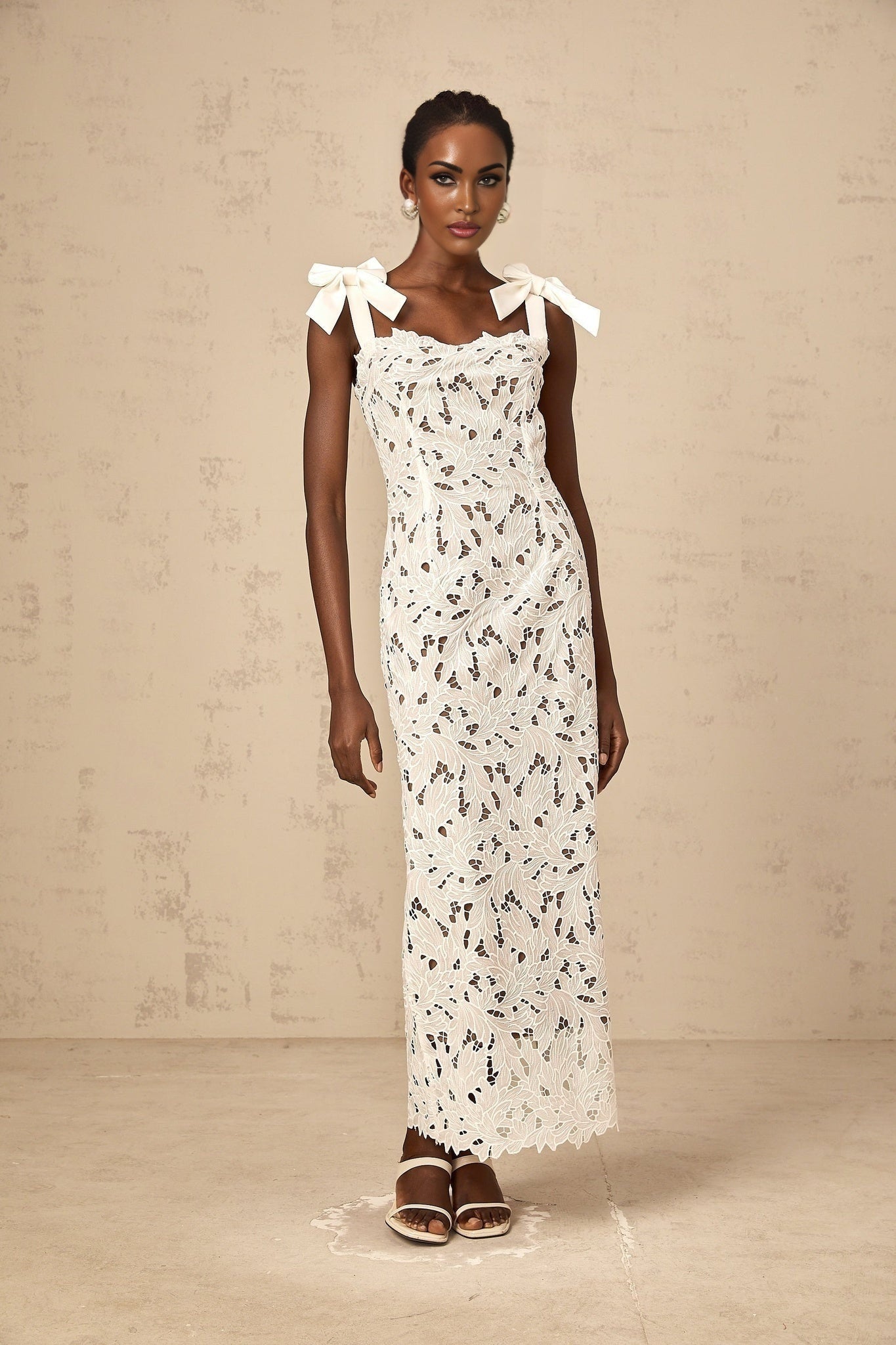 Woman wearing long white maxi dress with colorful floral embroidery details