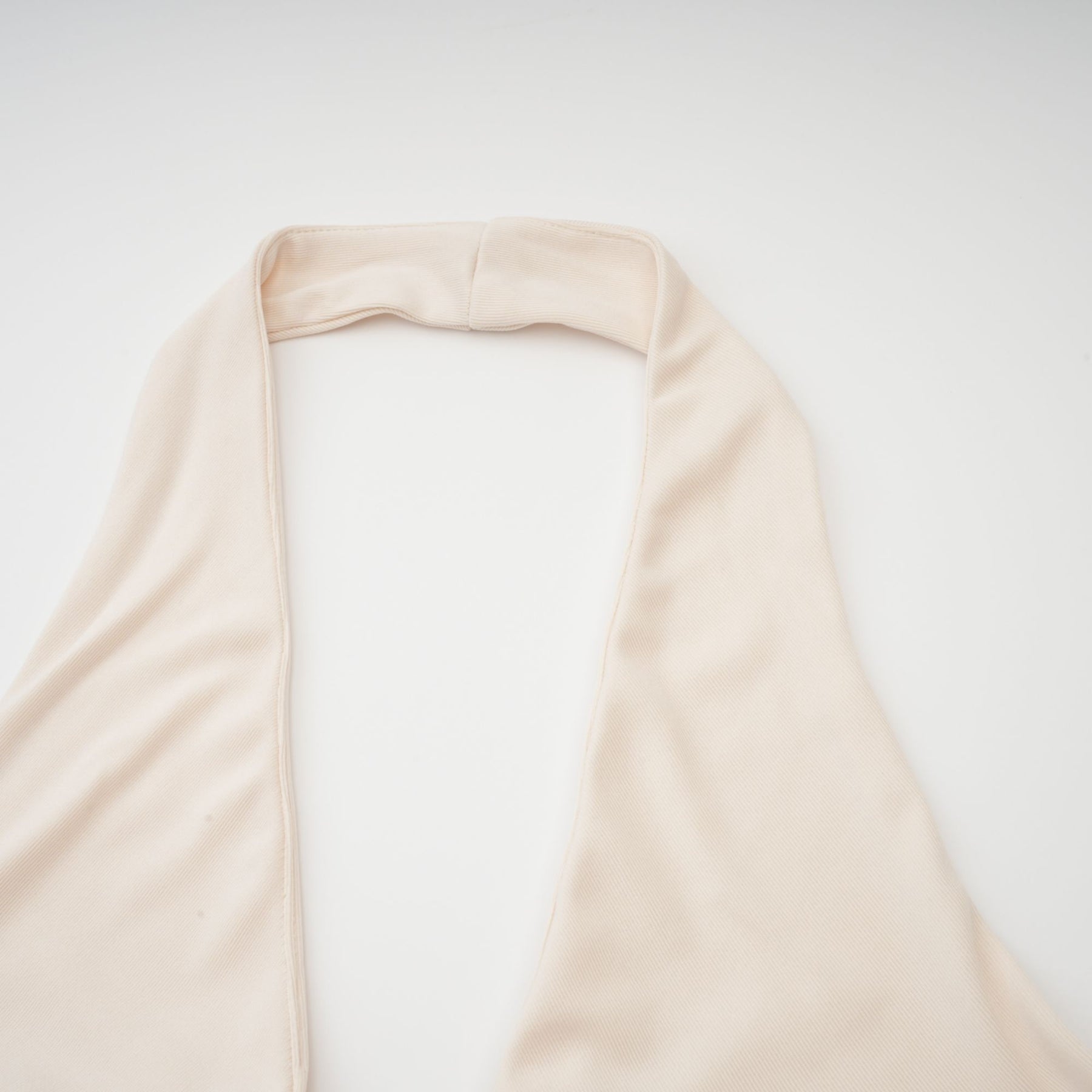 Woman wearing long white maxi dress with deep V neckline and draped fabric