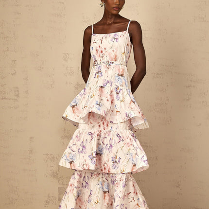 Woman wearing long white maxi dress with floral print and tiered ruffles