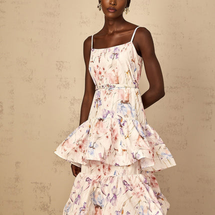 Woman wearing long white maxi dress with floral print and tiered ruffles