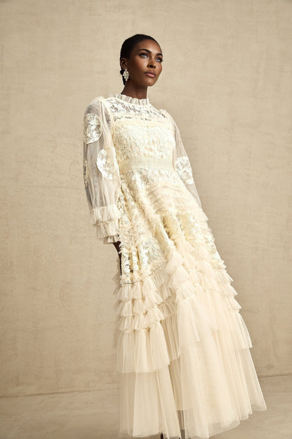 Woman wearing long white tulle maxi dress with floral embroidery and layered skirt