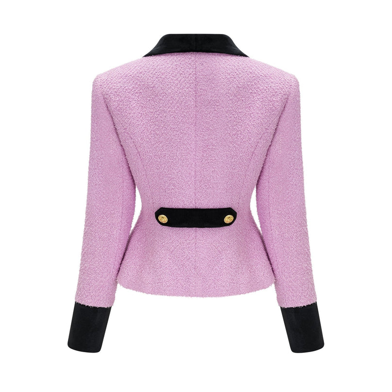 Woman wearing matching blue blazer and skirt set standing in front of white background