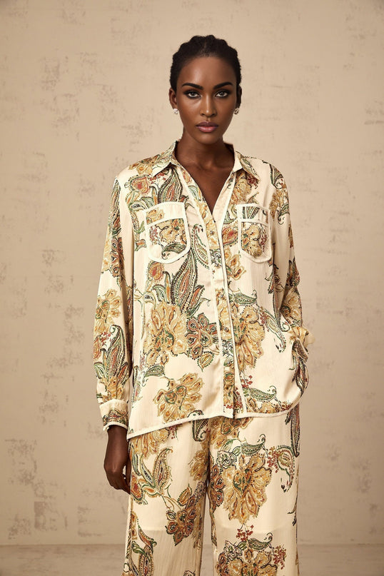 Woman wearing matching floral print shirt and trousers in neutral colors