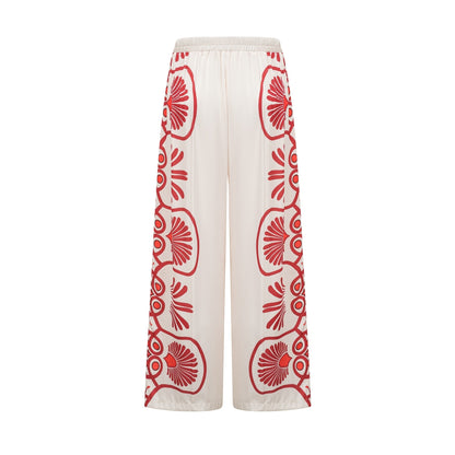 Woman wearing matching floral print shirt and trousers set in vibrant colors with Amaranta design