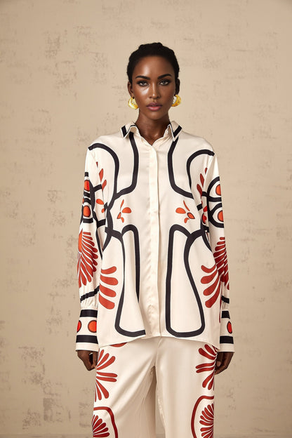 Woman wearing matching floral print shirt and trousers set in vibrant colors