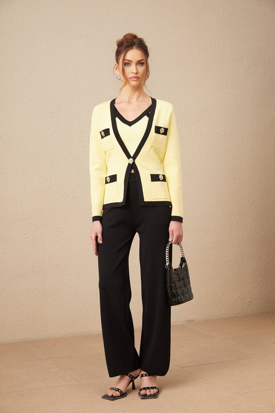 Woman wearing matching knit cardigan vest and trousers set in neutral color with contrasting trim