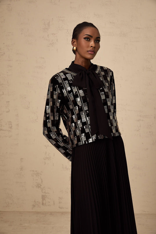 Woman wearing matching sequined cardigan and dress set in checkered pattern