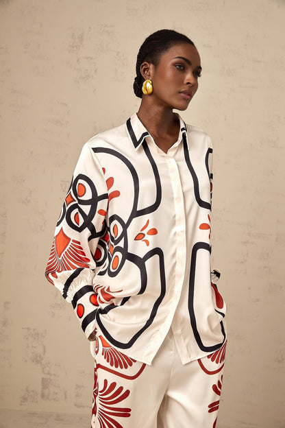 Woman wearing matching shirt and trousers set with colorful graphic print pattern