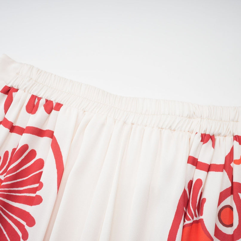 Woman wearing matching shirt and trousers set with graphic print pattern in Amaranta style