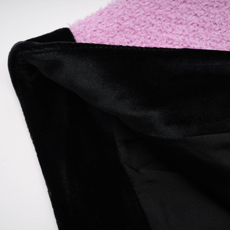 Woman wearing navy blue blazer and matching skirt set standing against white background