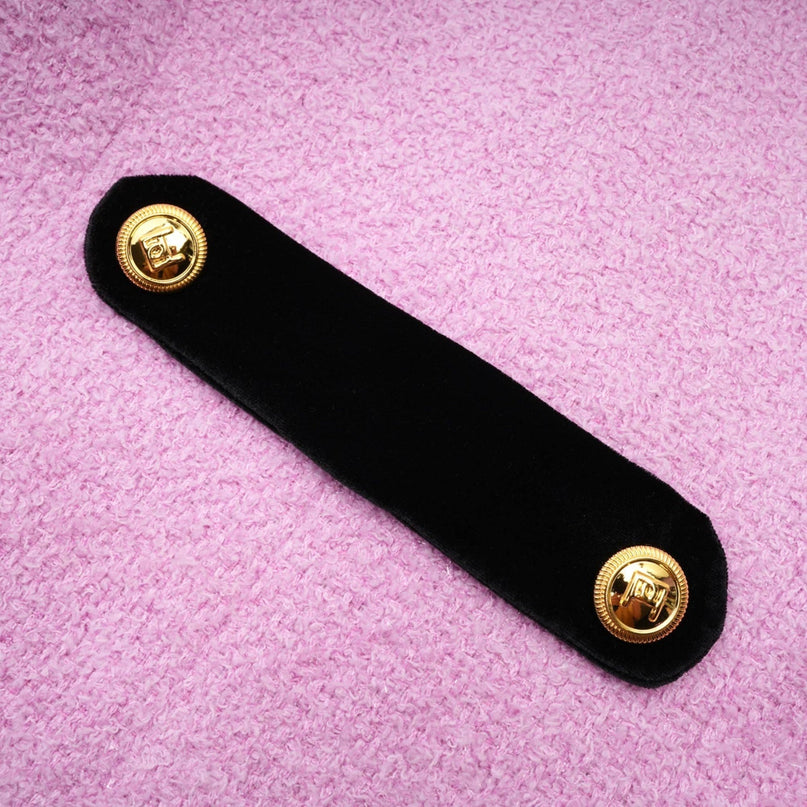 Woman wearing navy blue blazer and matching skirt set standing in front of plain background