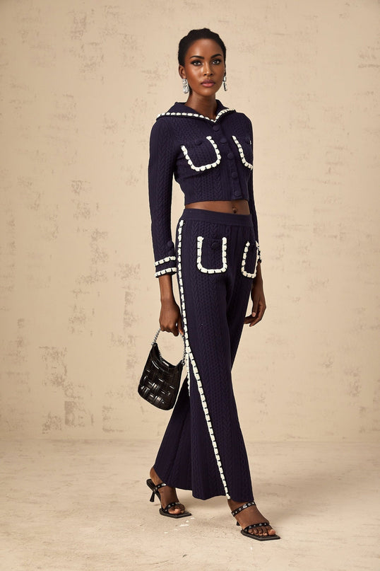 Woman wearing navy blue crochet knit cardigan and matching trousers set by Elvira
