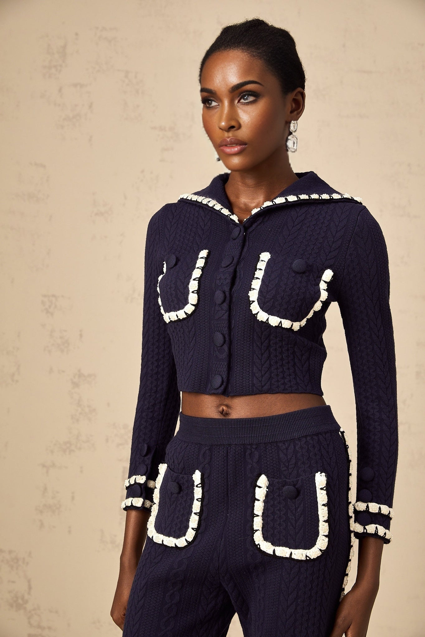 Woman wearing navy blue crochet knit cardigan and matching trousers set styled by Elvira