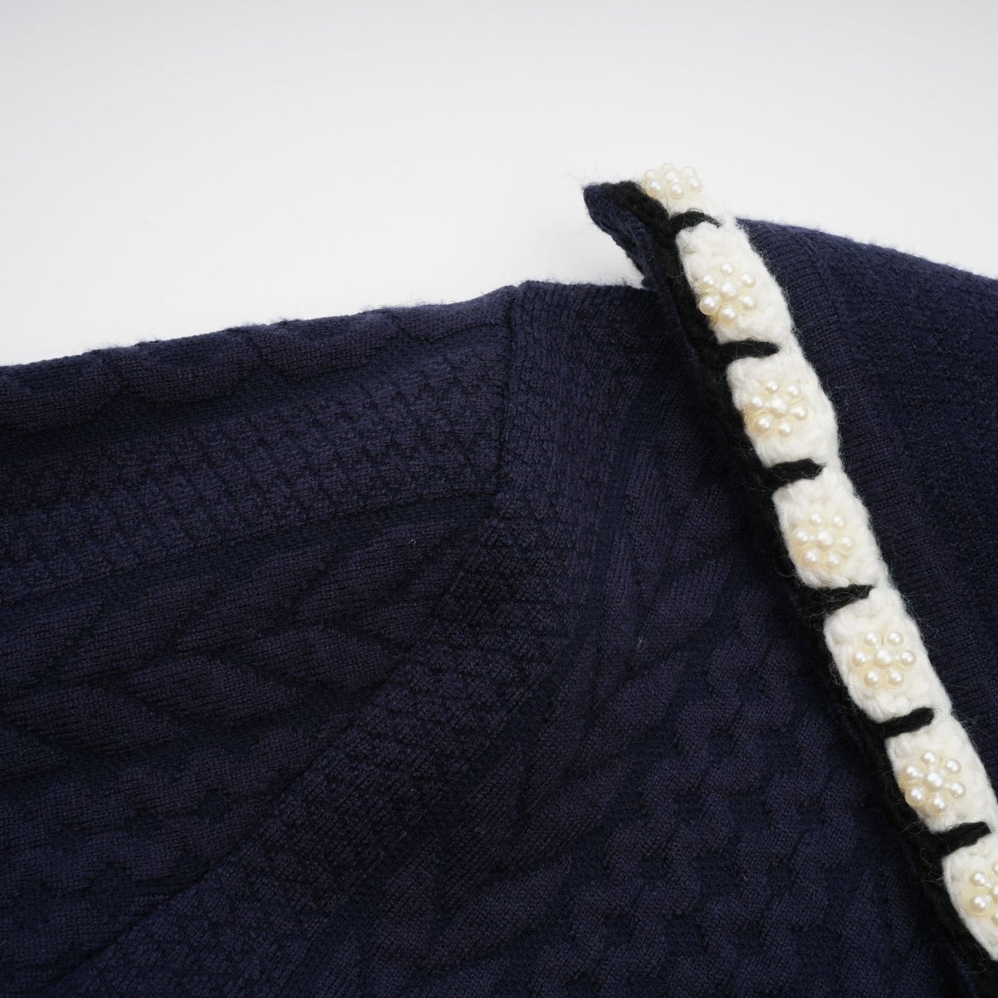 Woman wearing navy blue crochet knit cardigan and matching trousers set styled by Elvira