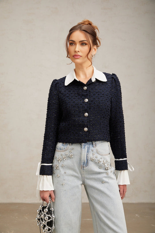 Woman wearing navy blue tweed jacket with panelled design and structured silhouette