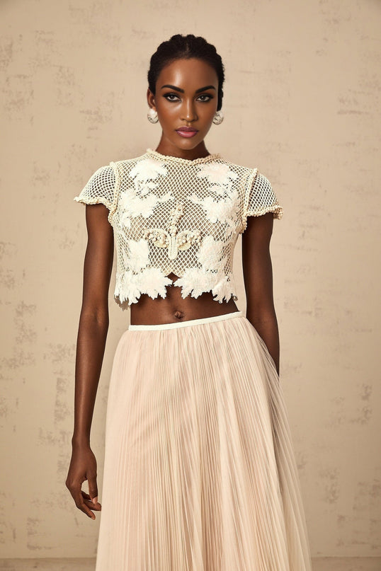 Woman wearing neutral colored matching set with floral applique top and skirt