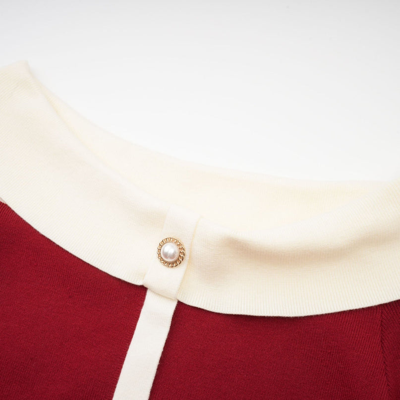 Woman wearing offshoulder knit midi dress in light color standing against plain background