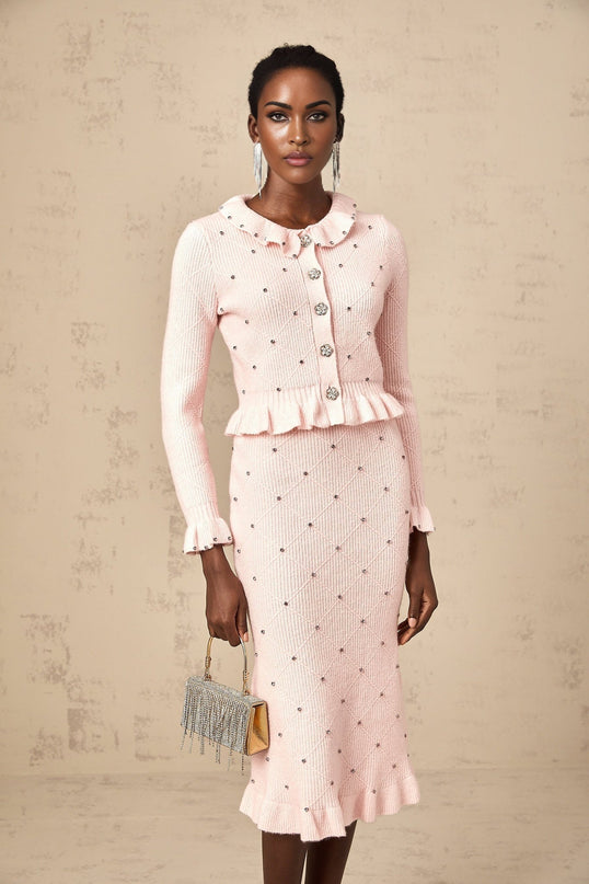 Woman wearing pink argyle patterned knit cardigan and matching skirt set