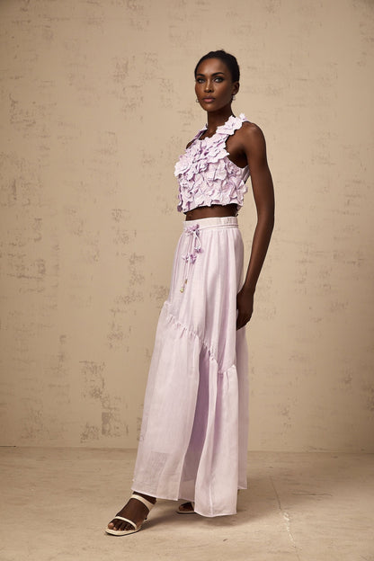 Woman wearing purple floral top and matching skirt set with faux flower pattern