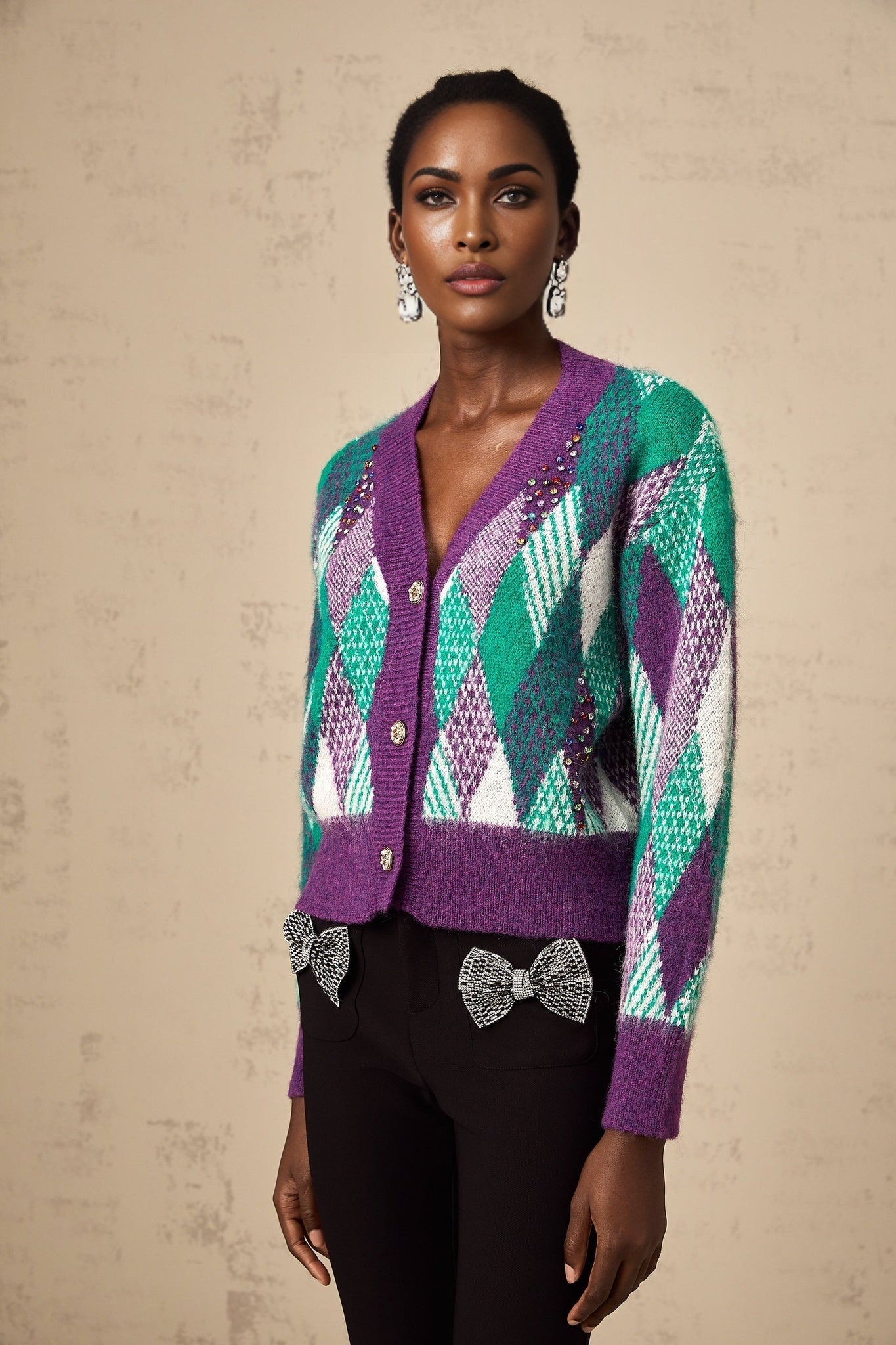 Woman wearing purple knit top with argyle pattern long sleeves and round neckline