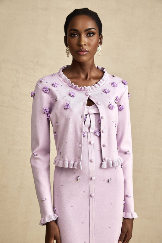Woman wearing purple knitted cardigan over matching dress with faux flower embellishments Estelle matching set