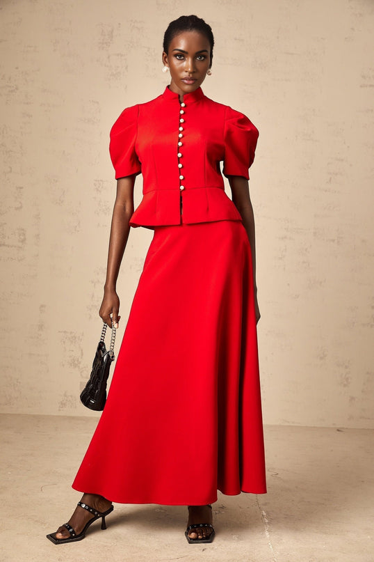 Woman wearing red pleated blouse and matching skirt set Colette style outfit with flowy fabric
