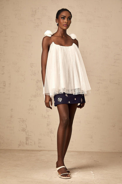 Woman wearing sheer white mesh top with floral applique details