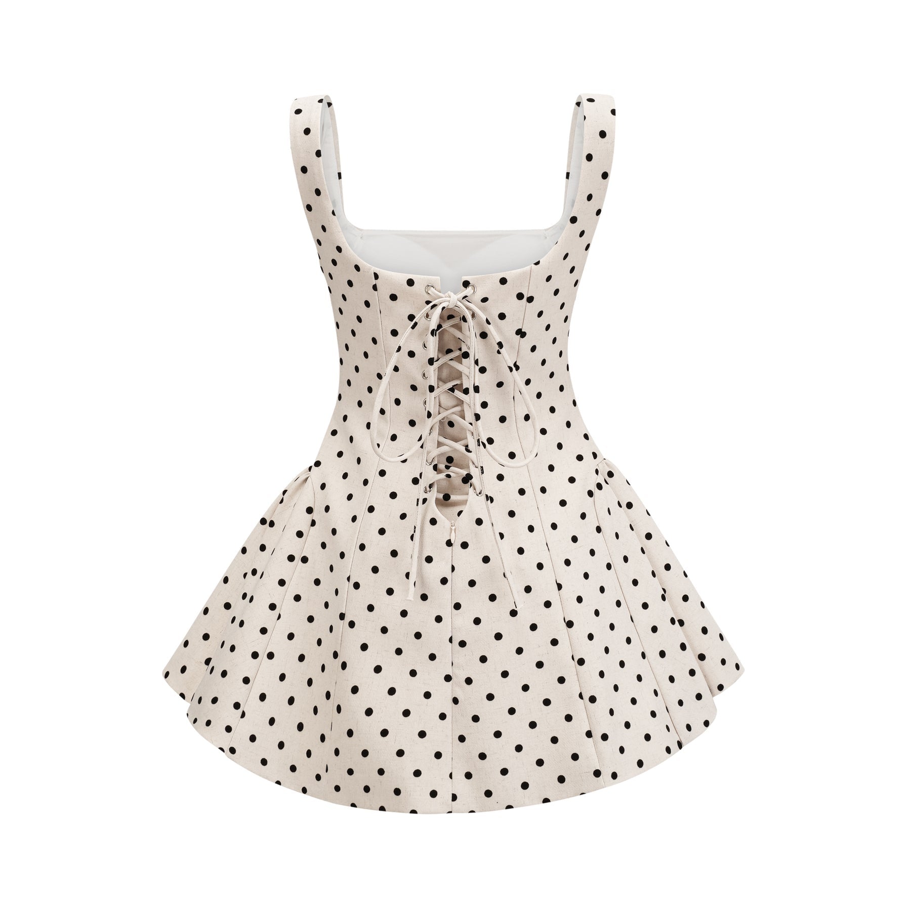 Woman wearing short beige polka dot dress with puffed sleeves and gathered waist