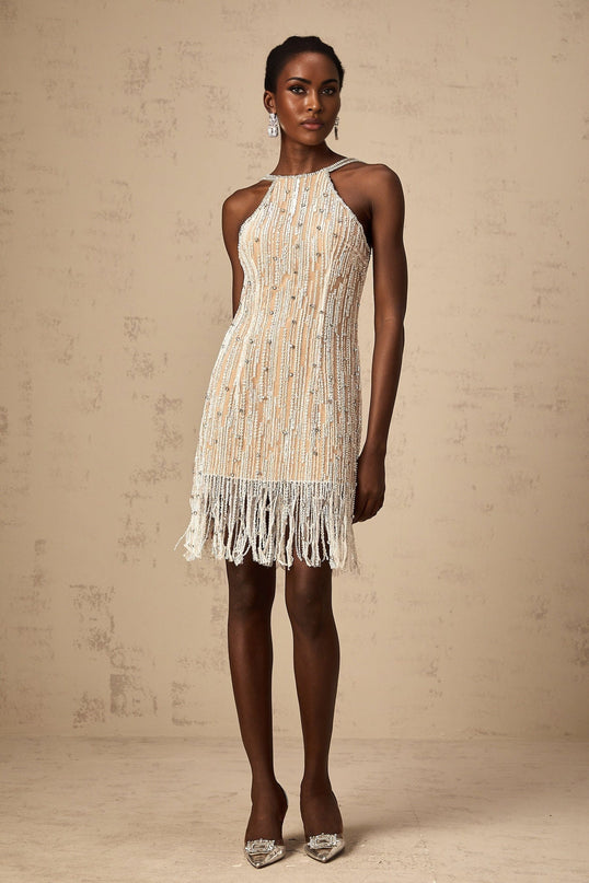 Woman wearing short black dress with beaded fringe detailing and embellishments