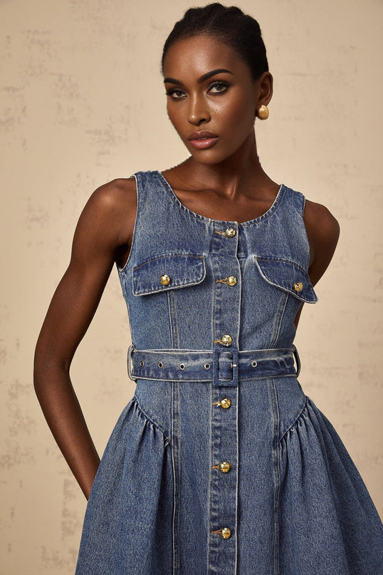 Woman wearing short blue denim dress with belt cinched at waist