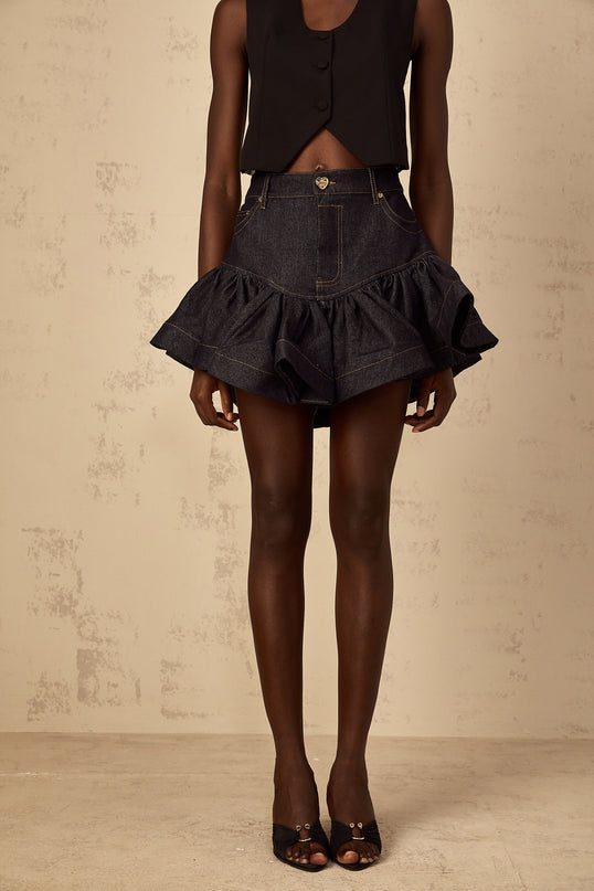 Woman wearing short blue denim skirt with ruffled hem