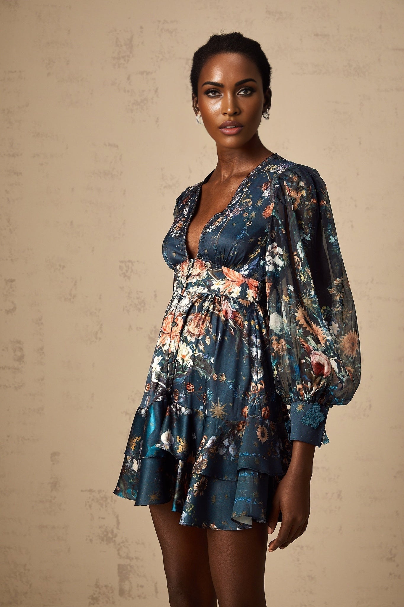 Woman wearing short light blue dress with graphic print pattern and embellishments