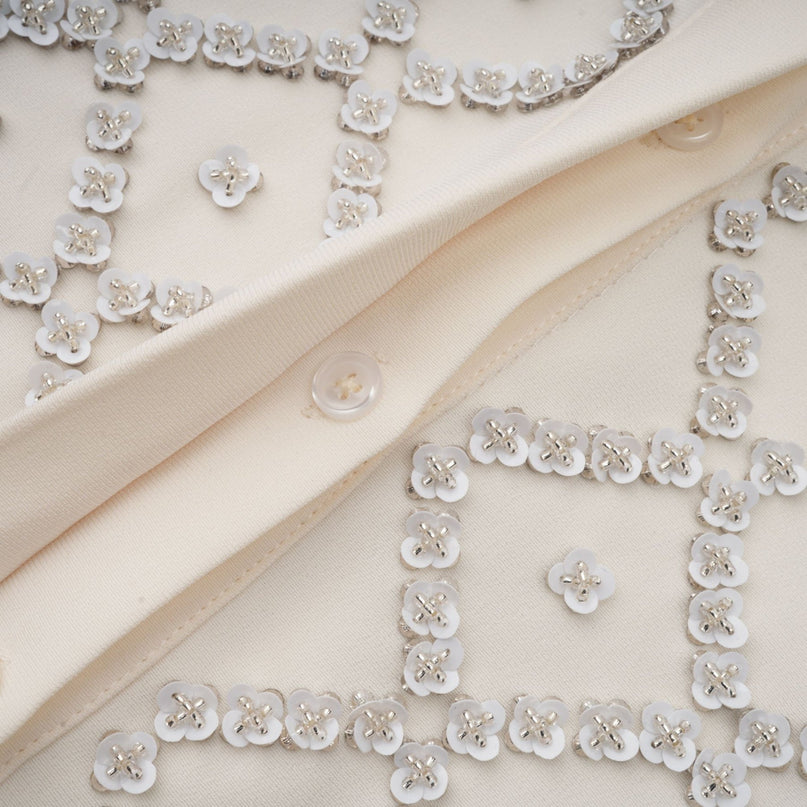 Woman wearing short sleeveless dress with contrasting colors and embellishments