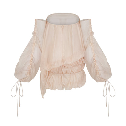 Woman wearing short white layered dress with off shoulder design and ruched fabric tied at waist