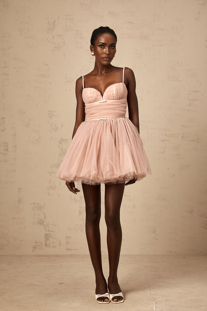 Woman wearing short white sleeveless dress with pleated tulle skirt