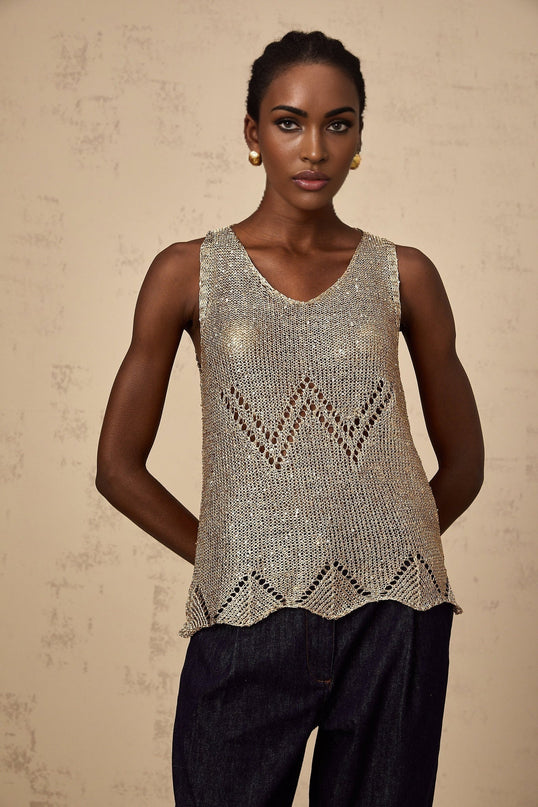 Woman wearing sleeveless gold vest top with sequin embellishments and crochet pattern design