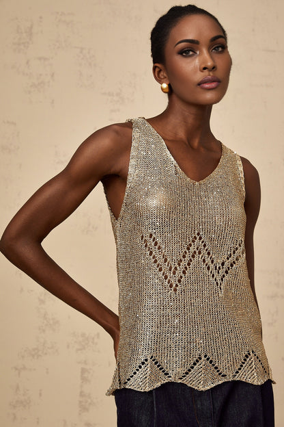 Woman wearing sleeveless gold vest top with sequin embellishments and crochet pattern design