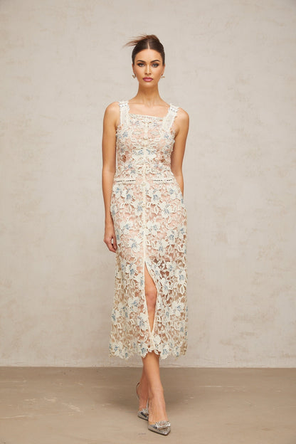 Woman wearing white Aline midi dress with floral lace pattern standing in neutral background