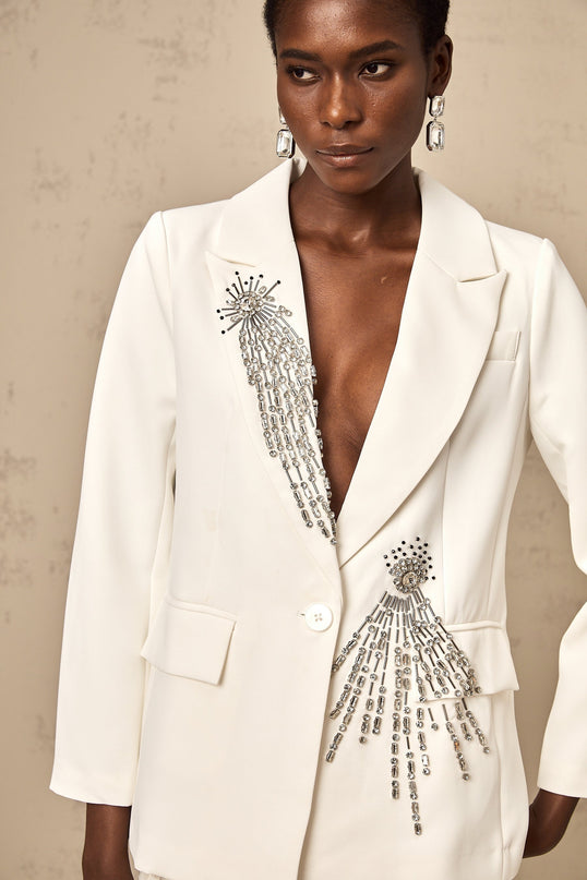 Woman wearing white blazer adorned with crystal embellishments elegant formal attire