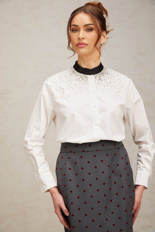 Woman wearing white buttonup shirt adorned with sparkling crystal embellishments