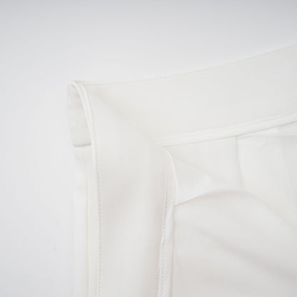 Woman wearing white creased top and matching trousers set