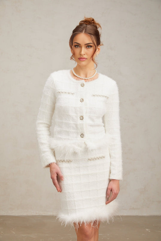 Woman wearing white feather waffle knit cardigan and matching skirt set