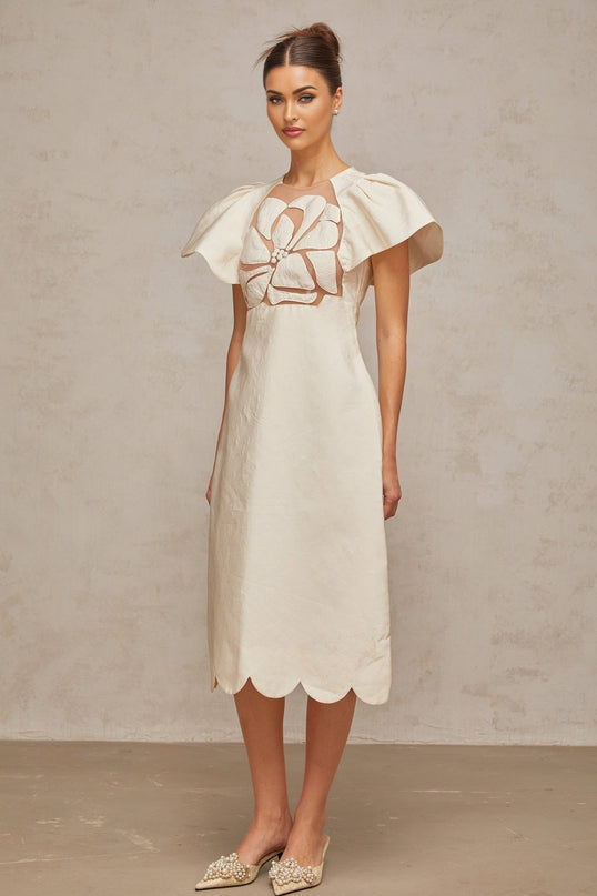 Woman wearing white floral jacquard midi dress with delicate pattern standing in elegant pose