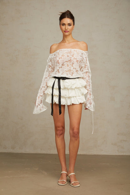 Woman wearing white floral lace top and matching skirt set called Aveline