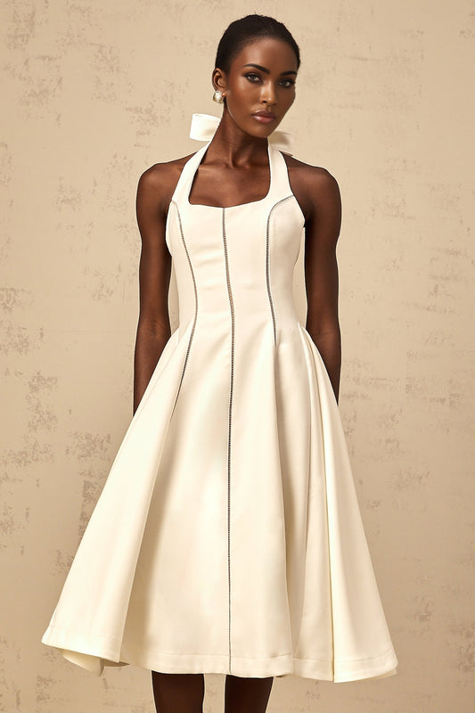 Woman wearing white halterneck midi dress with bow detail at neckline