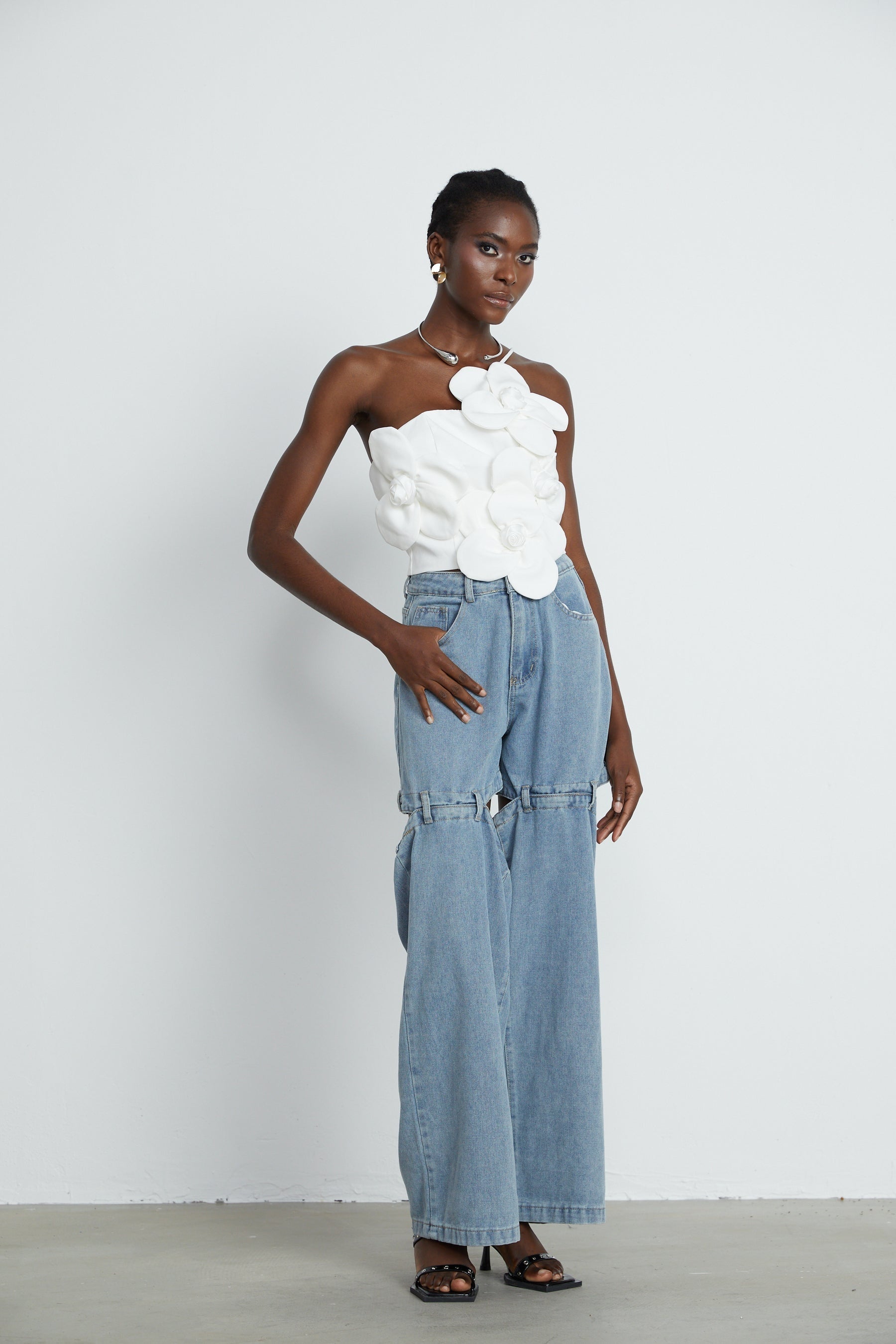Woman wearing white halterneck top with colorful floral appliques