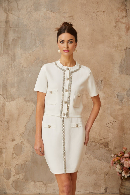 Woman wearing white knit top and skirt set with crystal embellishments
